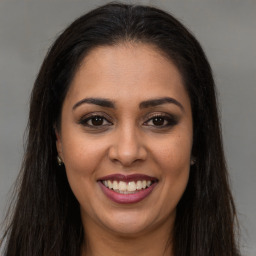 Joyful latino young-adult female with long  brown hair and brown eyes