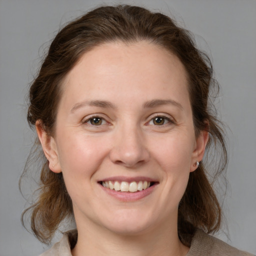 Joyful white young-adult female with medium  brown hair and grey eyes