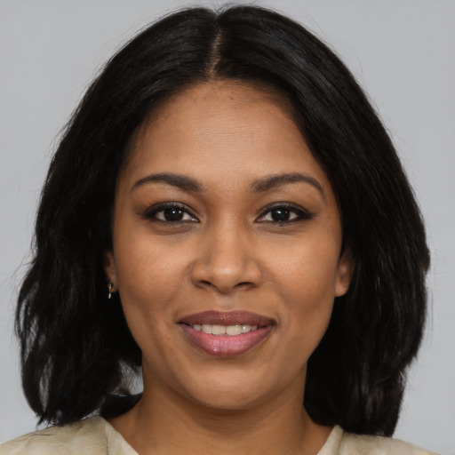 Joyful black young-adult female with long  black hair and brown eyes