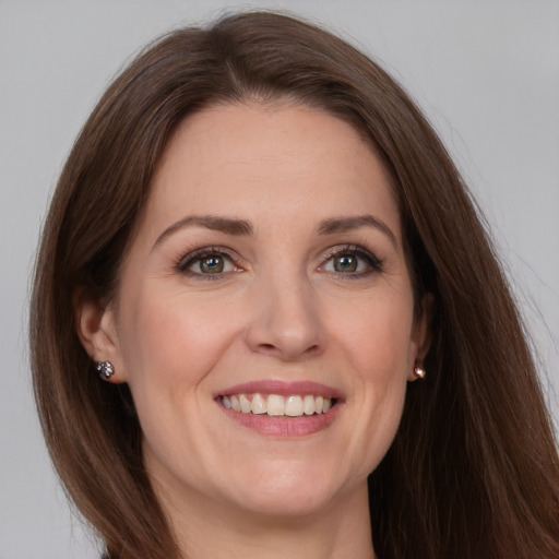 Joyful white adult female with long  brown hair and grey eyes