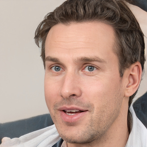 Joyful white adult male with short  brown hair and grey eyes