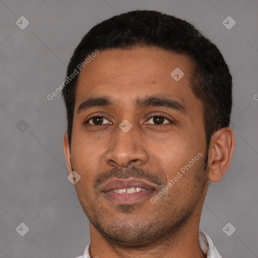 Joyful latino young-adult male with short  black hair and brown eyes