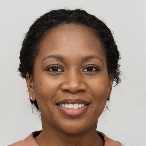Joyful black young-adult female with short  brown hair and brown eyes