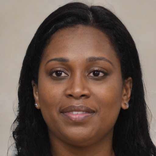 Joyful black young-adult female with long  brown hair and brown eyes