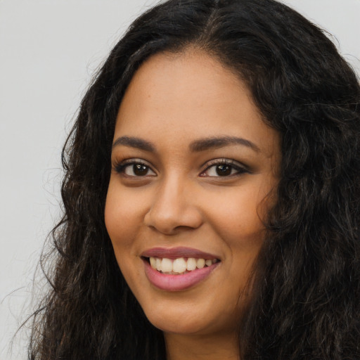 Joyful latino young-adult female with long  black hair and brown eyes