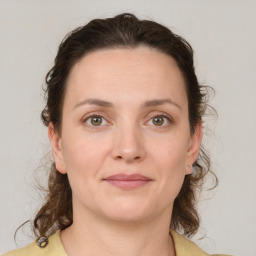 Joyful white young-adult female with medium  brown hair and green eyes