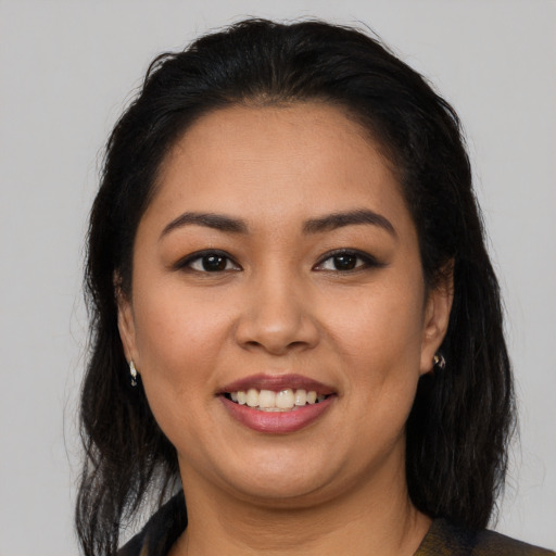 Joyful latino young-adult female with long  brown hair and brown eyes