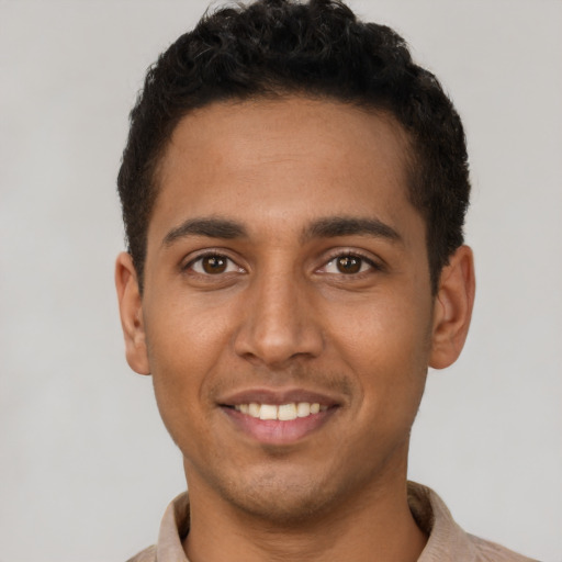 Joyful latino young-adult male with short  brown hair and brown eyes