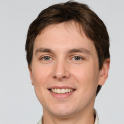 Joyful white young-adult male with short  brown hair and grey eyes