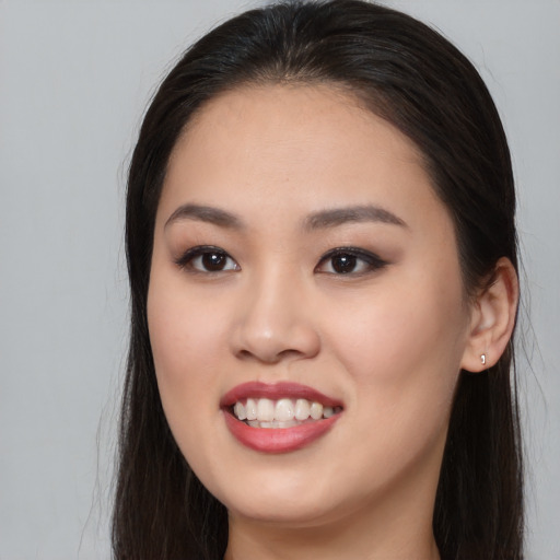 Joyful asian young-adult female with long  brown hair and brown eyes