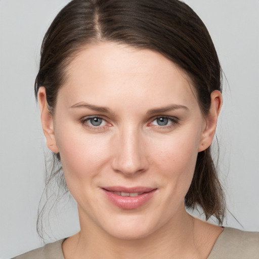 Joyful white young-adult female with medium  brown hair and grey eyes