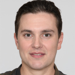 Joyful white young-adult male with short  brown hair and grey eyes