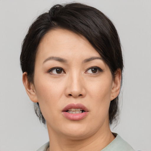 Joyful asian adult female with medium  brown hair and brown eyes
