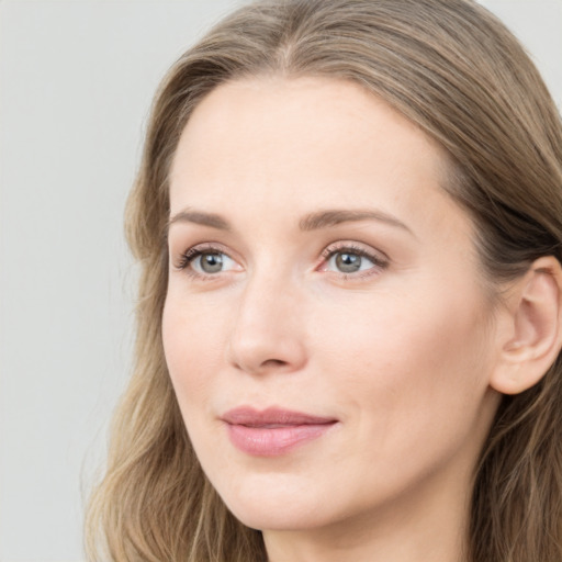 Joyful white young-adult female with long  brown hair and blue eyes