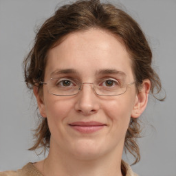 Joyful white adult female with medium  brown hair and blue eyes