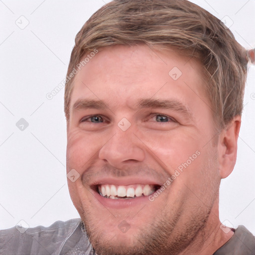 Joyful white adult male with short  brown hair and blue eyes