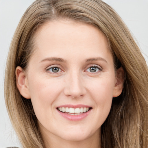 Joyful white young-adult female with long  brown hair and grey eyes