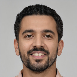 Joyful latino young-adult male with short  black hair and brown eyes