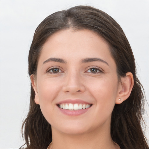 Joyful white young-adult female with long  brown hair and grey eyes