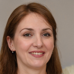 Joyful white adult female with long  brown hair and grey eyes