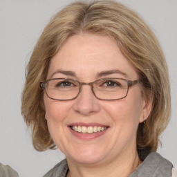 Joyful white adult female with medium  brown hair and blue eyes