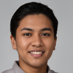 Joyful latino young-adult male with short  brown hair and brown eyes