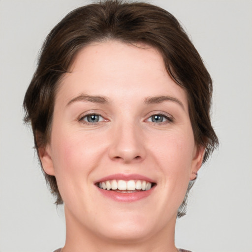 Joyful white young-adult female with medium  brown hair and green eyes