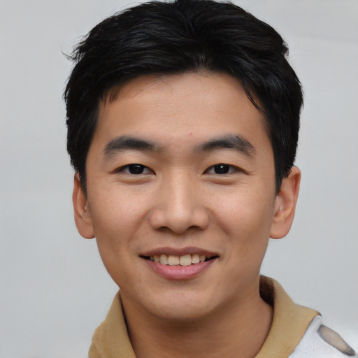 Joyful asian young-adult male with short  black hair and brown eyes