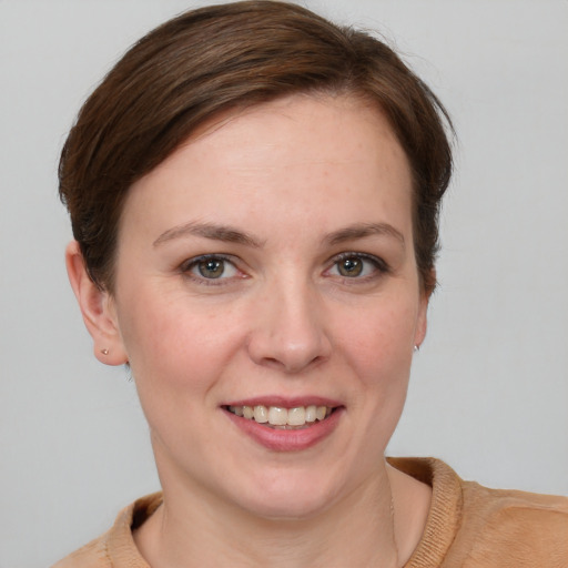 Joyful white young-adult female with short  brown hair and grey eyes