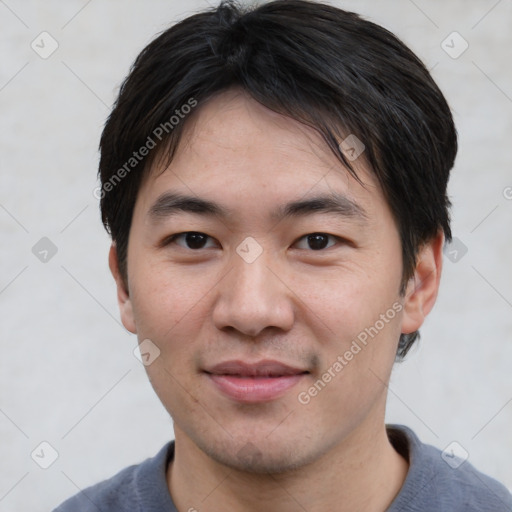 Joyful asian young-adult male with short  black hair and brown eyes