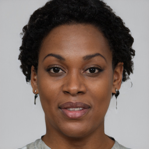Joyful black young-adult female with short  black hair and brown eyes