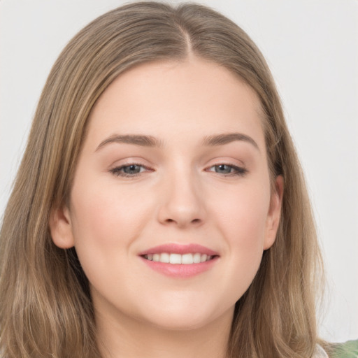 Joyful white young-adult female with long  brown hair and grey eyes