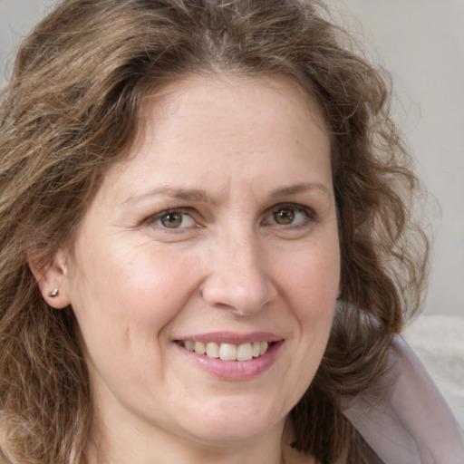 Joyful white adult female with medium  brown hair and grey eyes