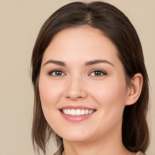 Joyful white young-adult female with long  brown hair and brown eyes