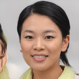 Joyful asian young-adult female with medium  black hair and brown eyes