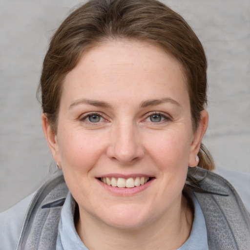 Joyful white young-adult female with medium  brown hair and blue eyes