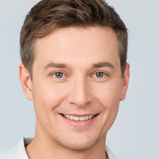 Joyful white young-adult male with short  brown hair and grey eyes