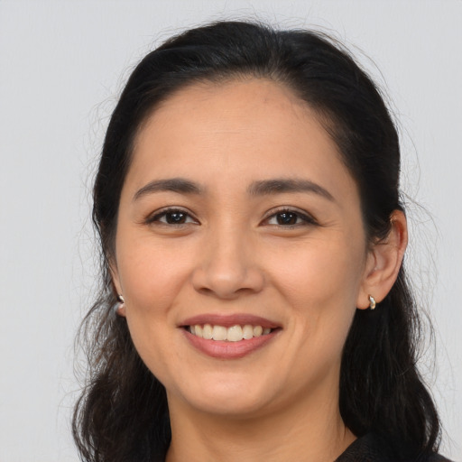 Joyful latino young-adult female with long  brown hair and brown eyes