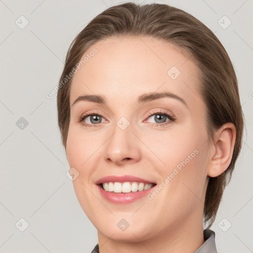 Joyful white young-adult female with medium  brown hair and grey eyes