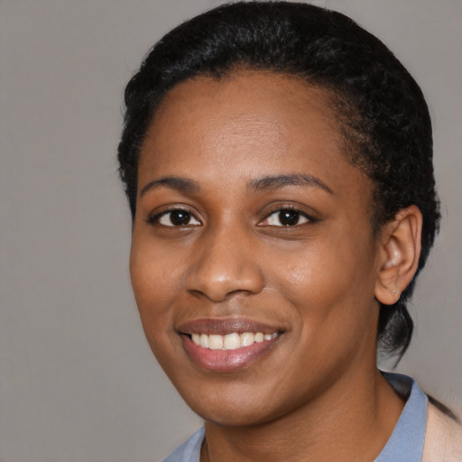 Joyful black young-adult female with short  black hair and brown eyes