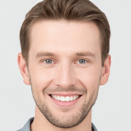 Joyful white young-adult male with short  brown hair and grey eyes