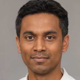 Joyful latino young-adult male with short  black hair and brown eyes