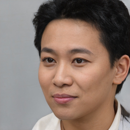 Joyful asian young-adult male with short  black hair and brown eyes