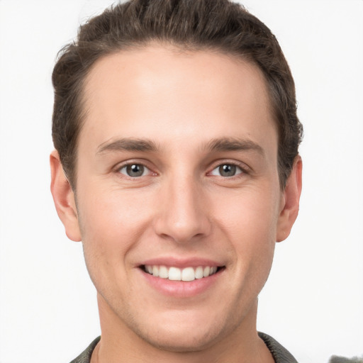 Joyful white young-adult male with short  brown hair and grey eyes