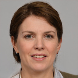 Joyful white adult female with medium  brown hair and grey eyes