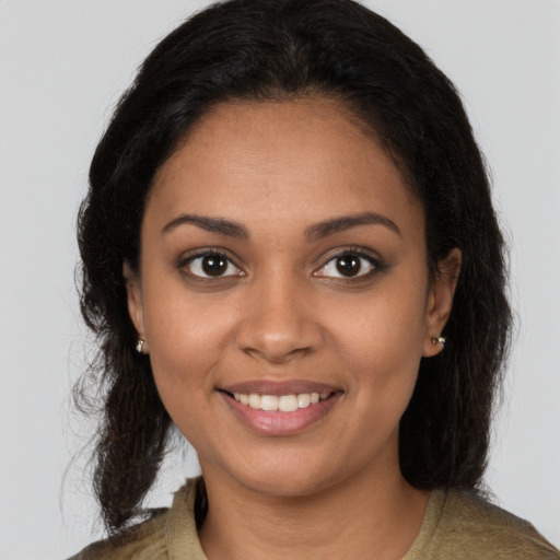 Joyful black young-adult female with long  brown hair and brown eyes