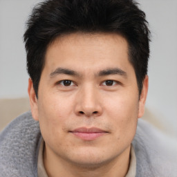 Joyful asian young-adult male with short  brown hair and brown eyes