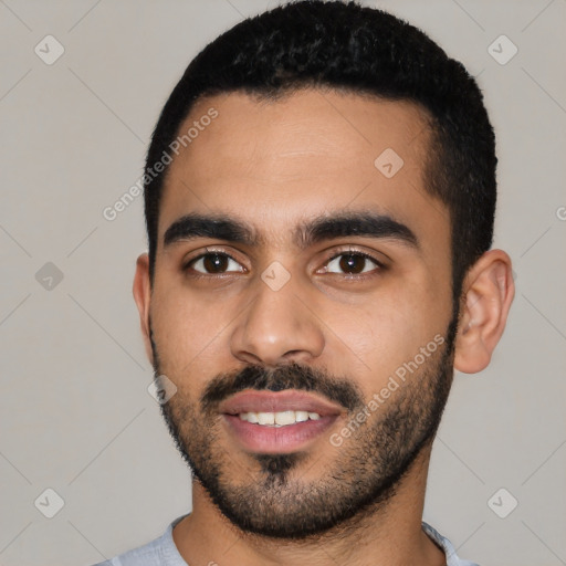 Joyful latino young-adult male with short  black hair and brown eyes