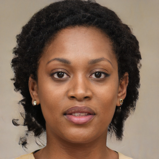 Joyful black young-adult female with long  brown hair and brown eyes