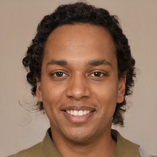 Joyful black young-adult male with short  brown hair and brown eyes